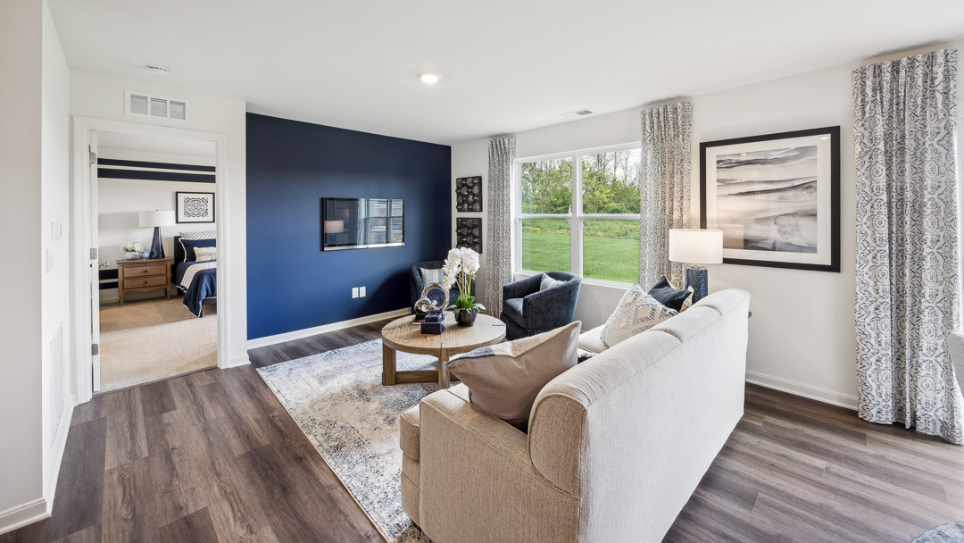 living room with tv mounted on wall and primary bedroom to the left
