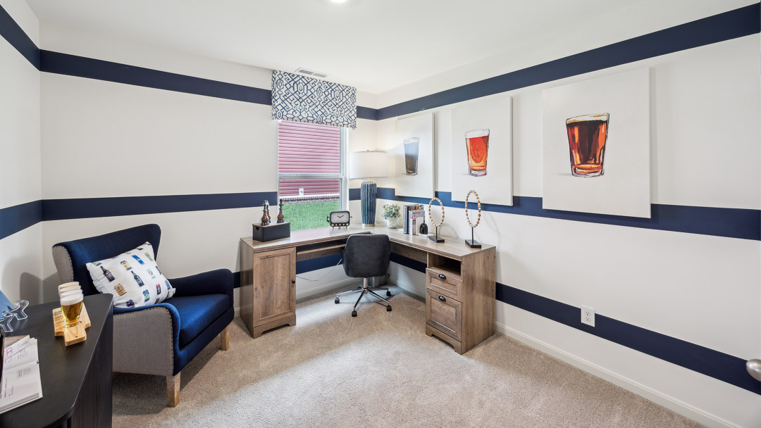 bedroom number 2 decorated as home office with large corner desk and accent chair