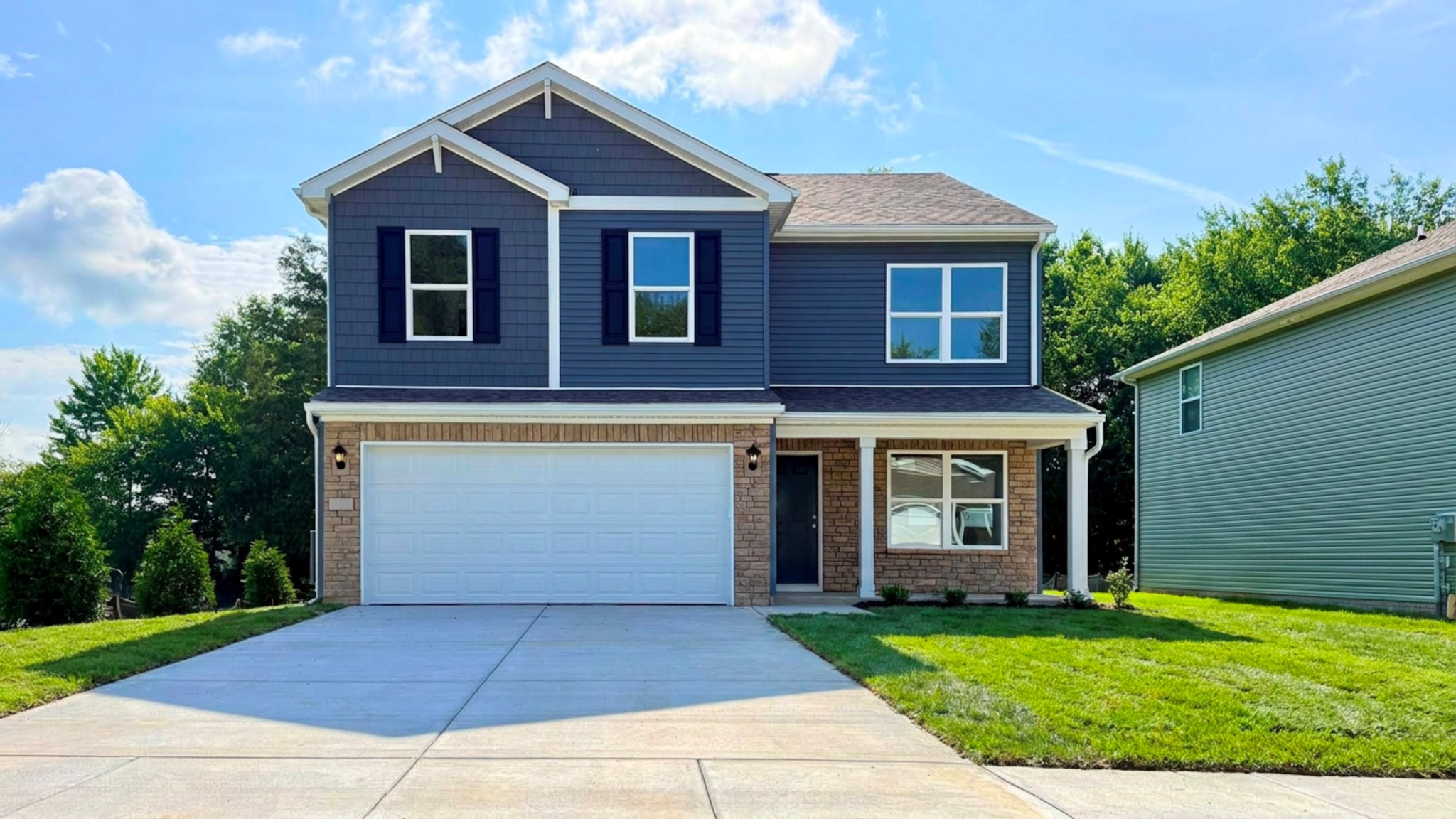 Quick-move in Bellamy floor plan with Riverway vinyl siding, stone accents, a covered front porch, and a 2-car attached garage.