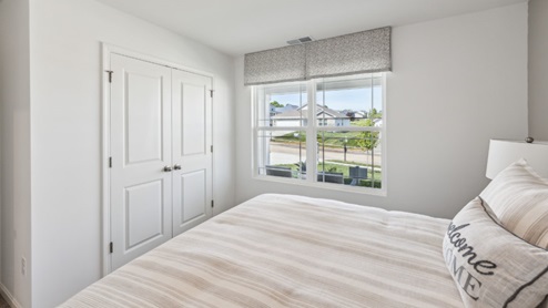 Bedroom with window and closed closet with white doors