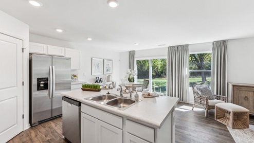 Open concept living space, view from kitchen island. Windows shown.