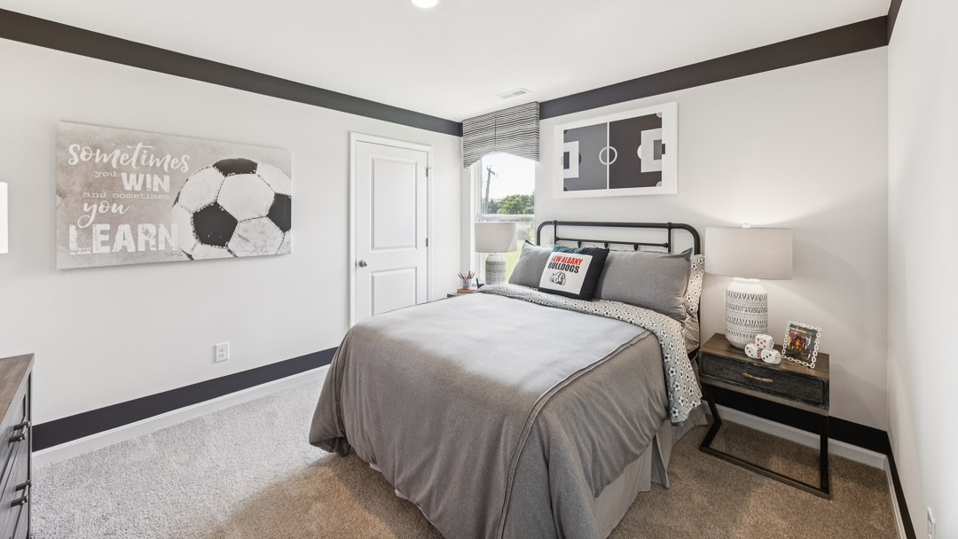 Upstairs spare bedroom decorated in soccer theme. Bed, nightstands, single window.