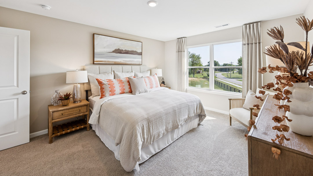 Upstairs primary bedroom with king size bed, 2 nightstands, dresser, and double window.