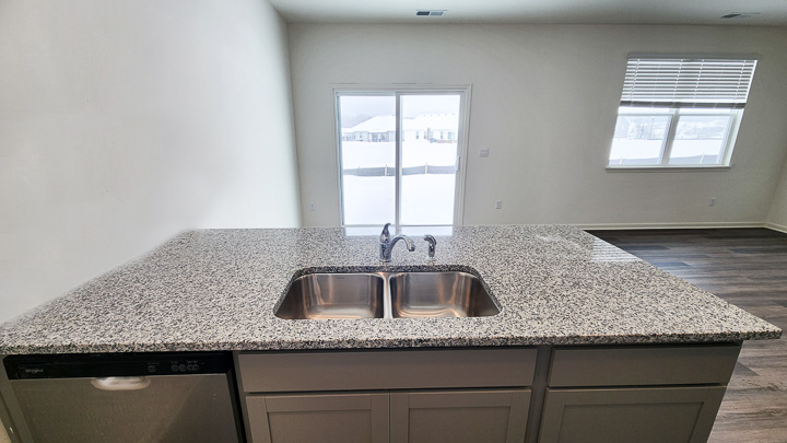 large  granite countertop overlooking dining area and sliding glass door
