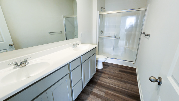 primary bathroom with double vanity sinks and shower