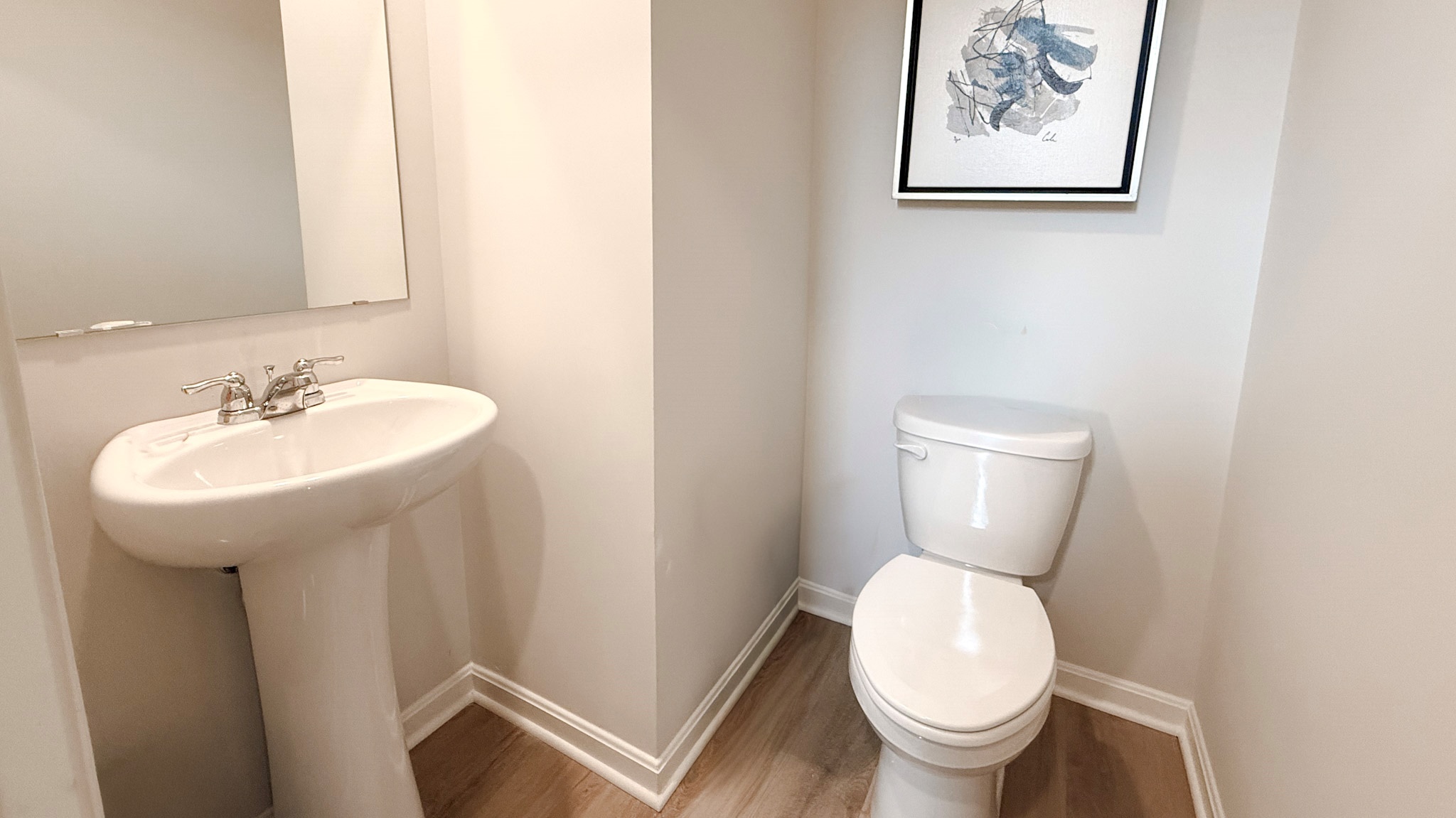 First floor half bathroom with pedestal sink and commode.