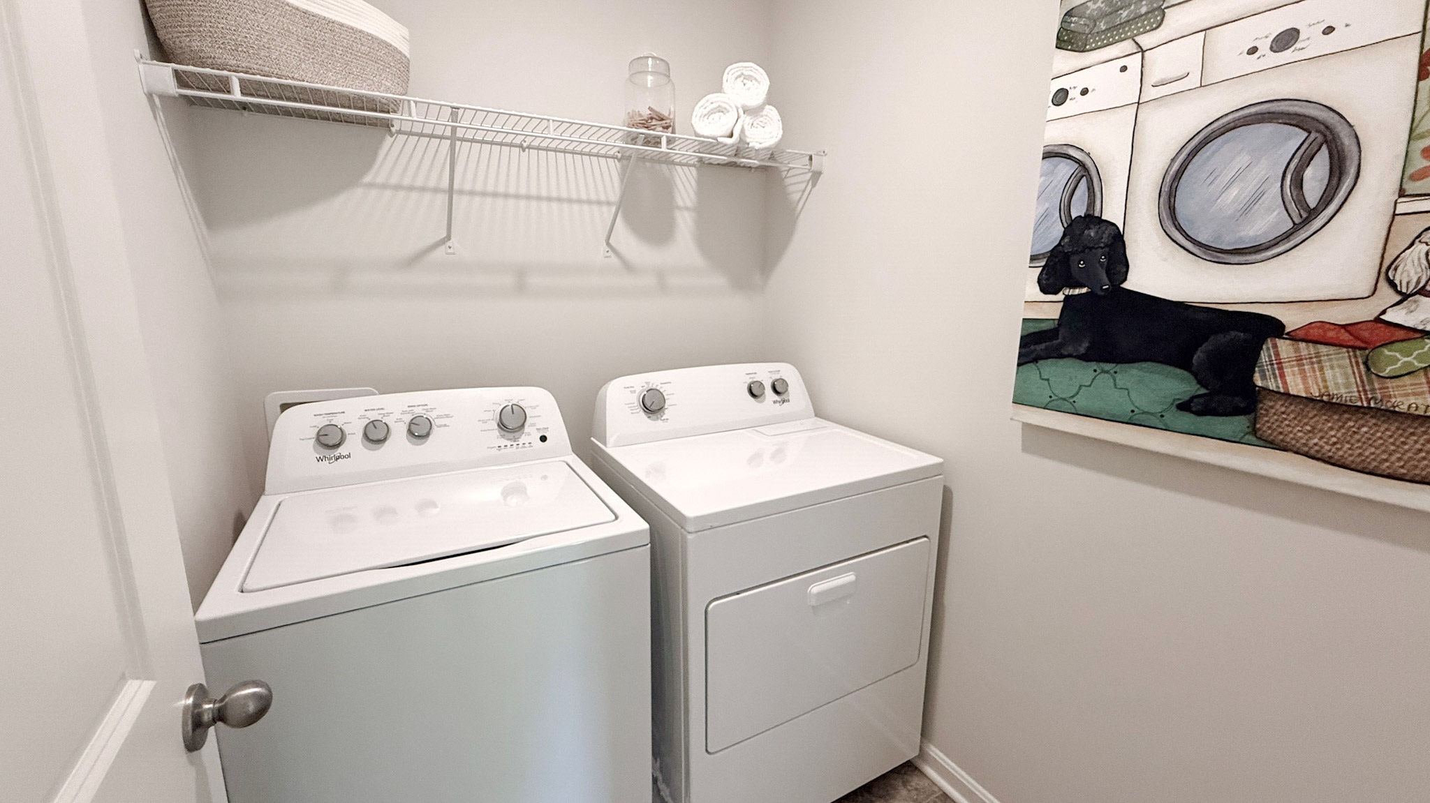 Second floor laundry room with wire shelf above the washer and dryer.