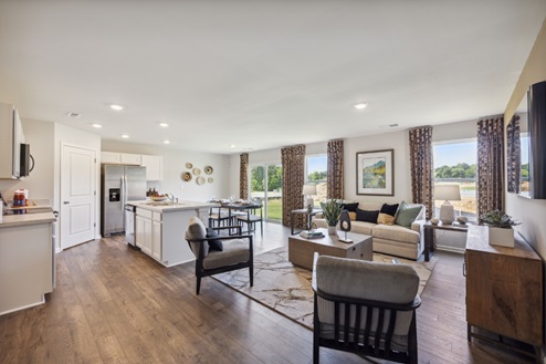 Open concept living area, large windows with patterned curtains, living room furniture, brown vinyl plank floors