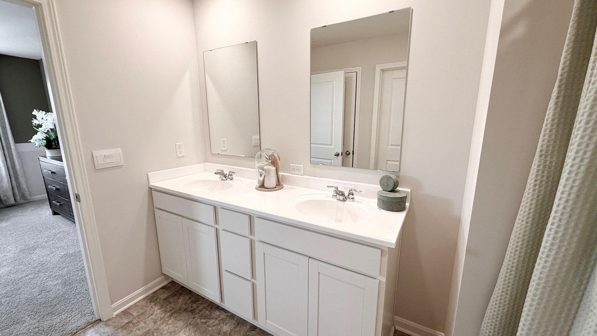 Double bowl vanity with mirrors above the sinks in the primary bathroom.