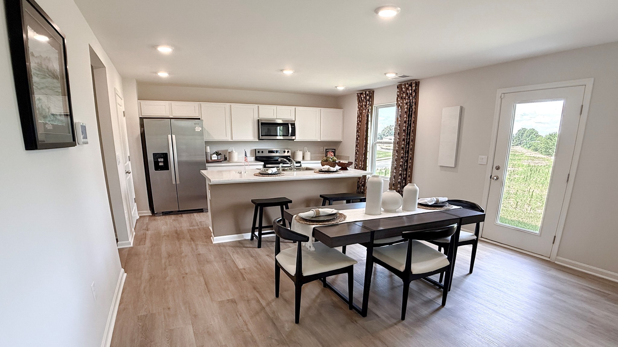 Kitchen and dining area with rectangular table and chairs.