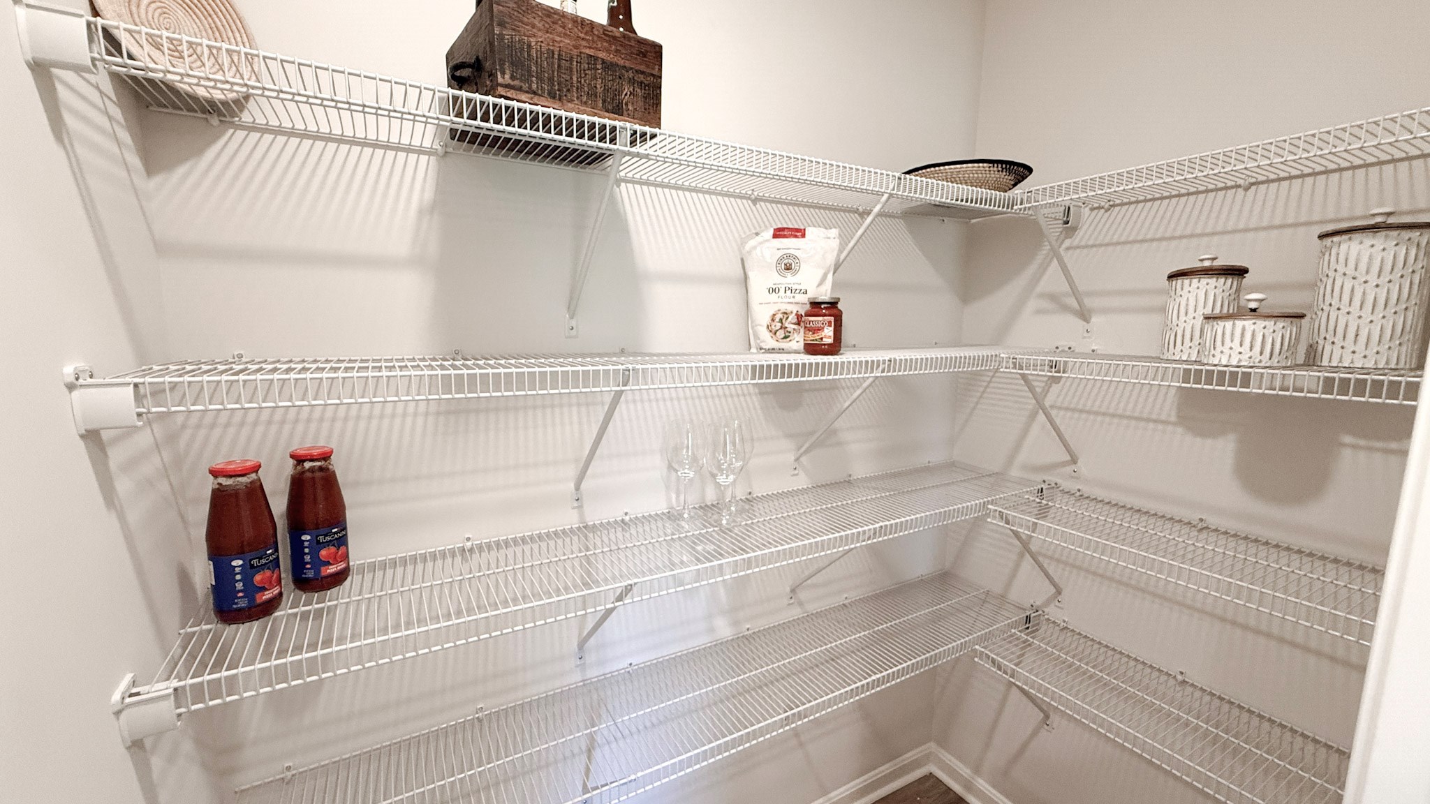 Walk-in kitchen pantry with wire shelving.