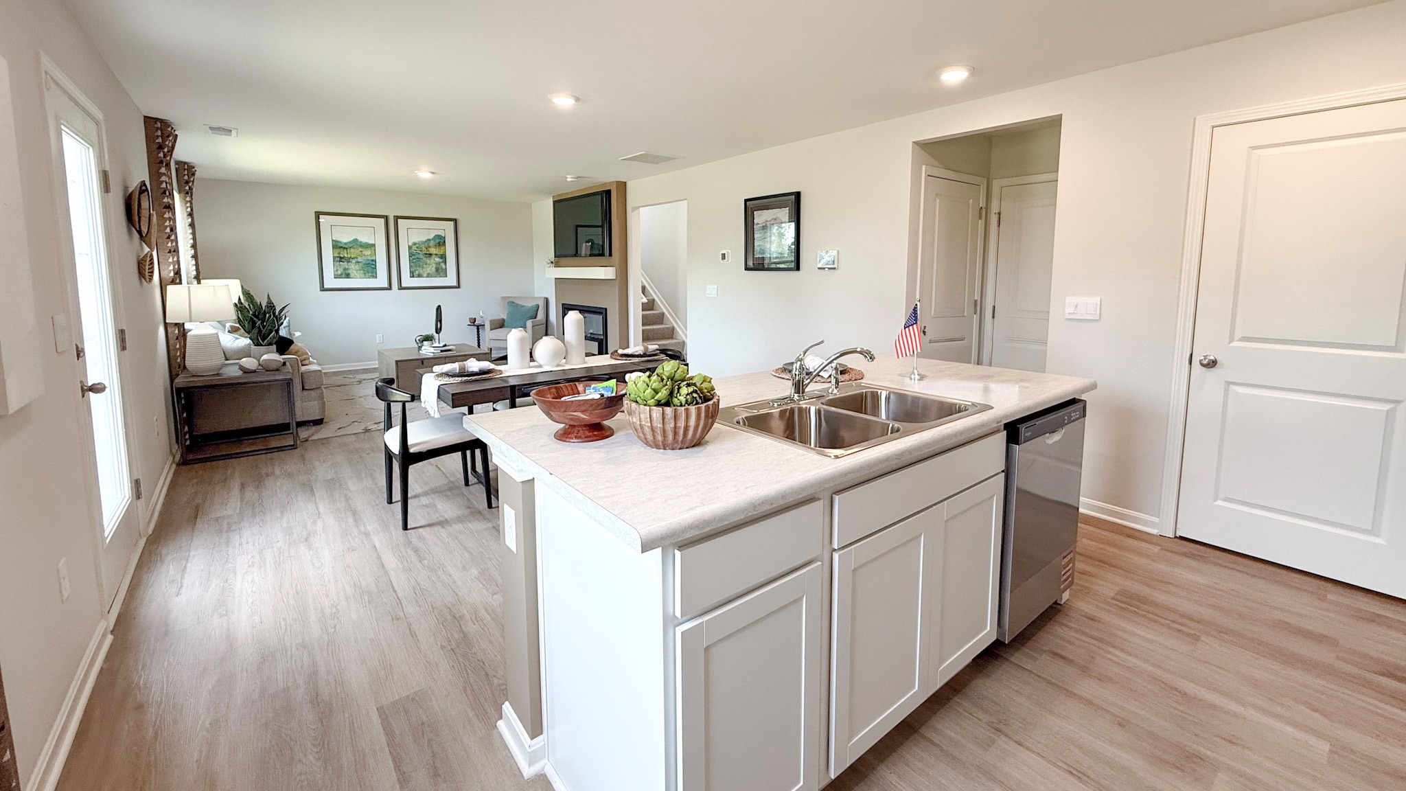 Kitchen island with built-in sink and dishwasher overlooking the dining area and living room.