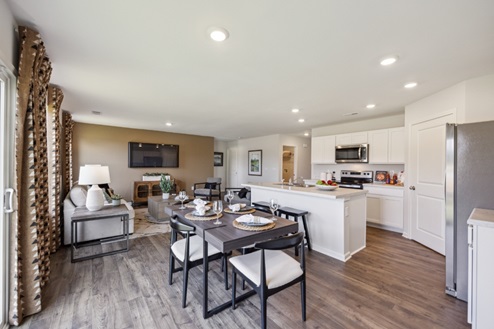 Casual dining area with table and chairs with view of open concept living room and kitchen
