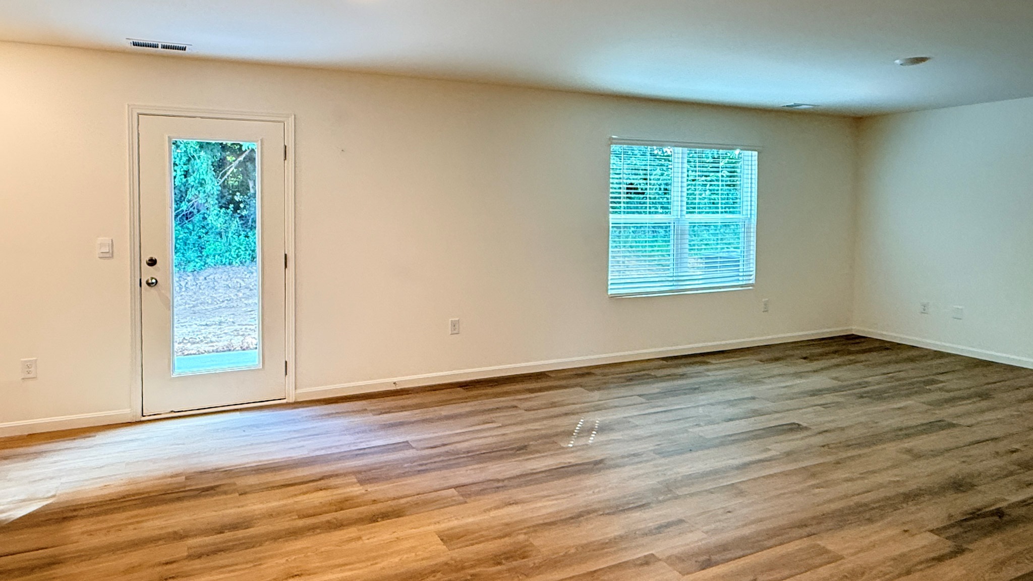 Dining area, single back door, and living room with a double window and LVP flooring.