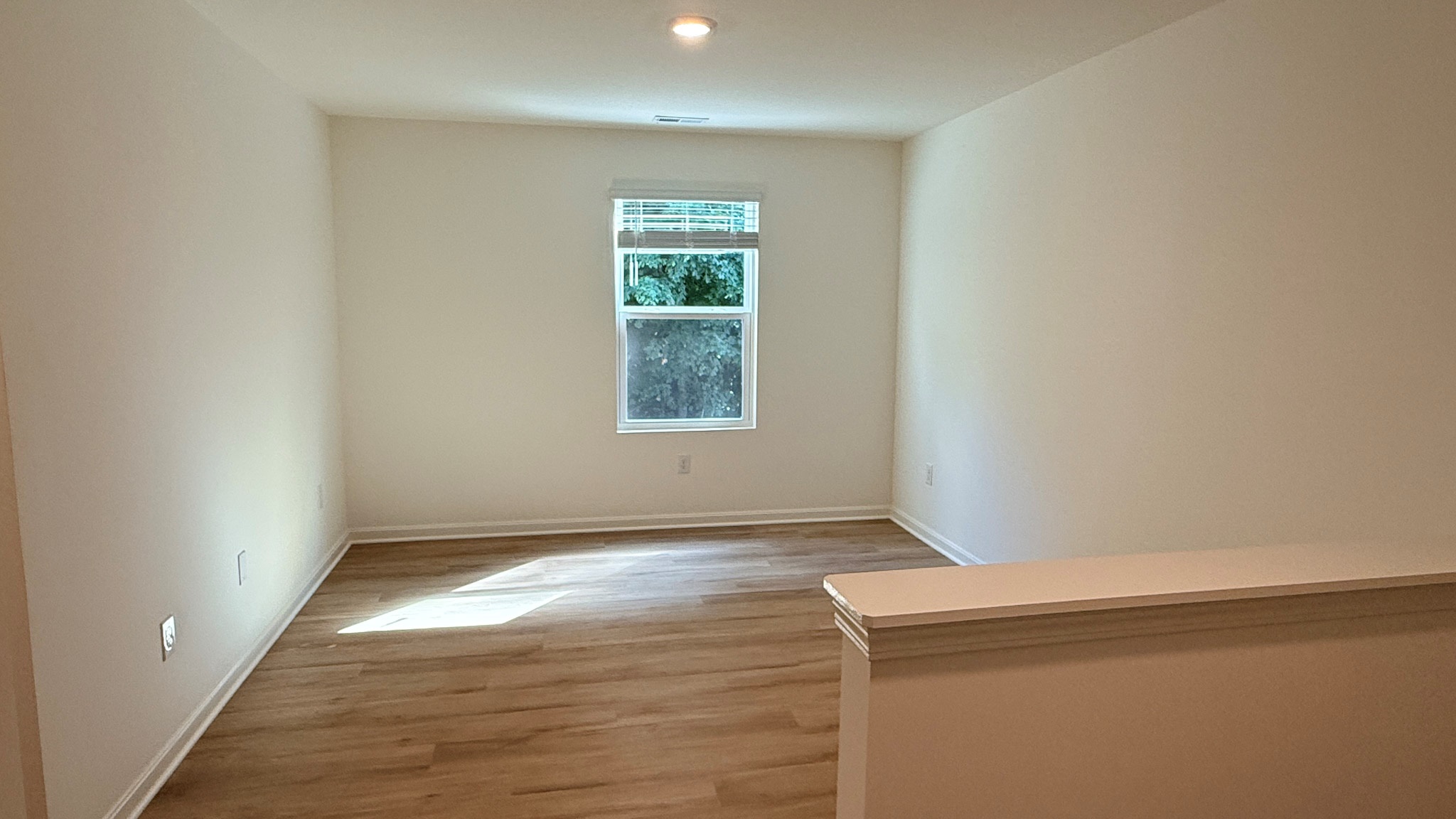 Second floor loft with single window and LVP flooring.