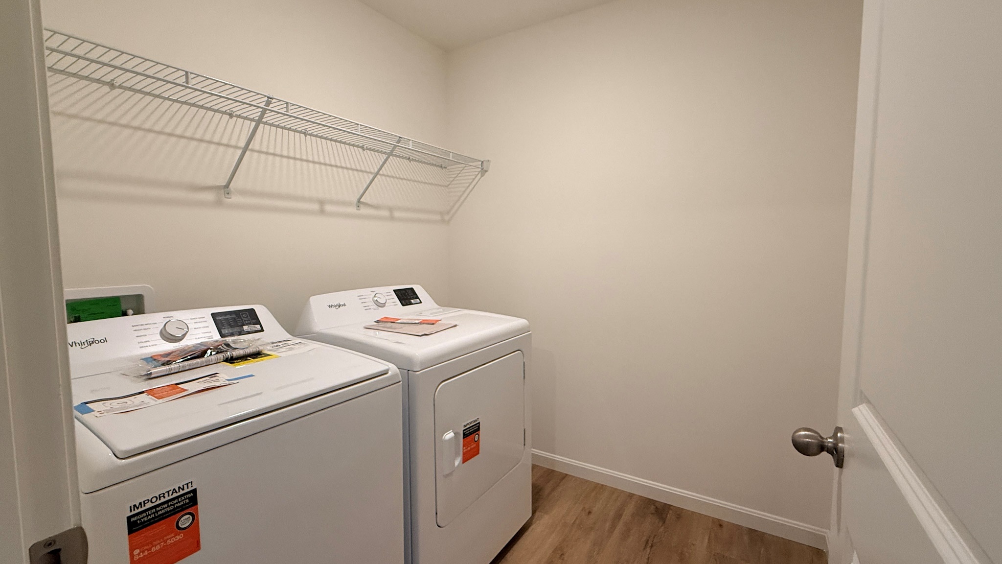 Second floor laundry room with wire shelf above the washer and dryer.