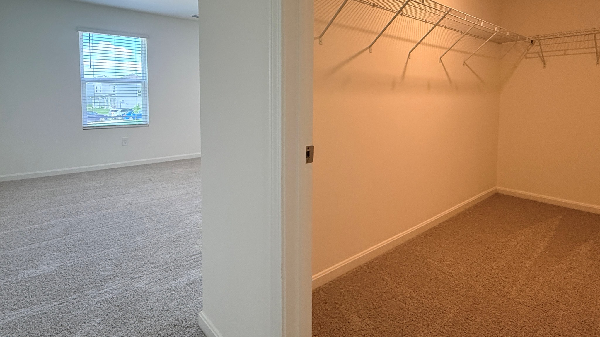 Primary bathroom and walk-in closet with wire shelving.