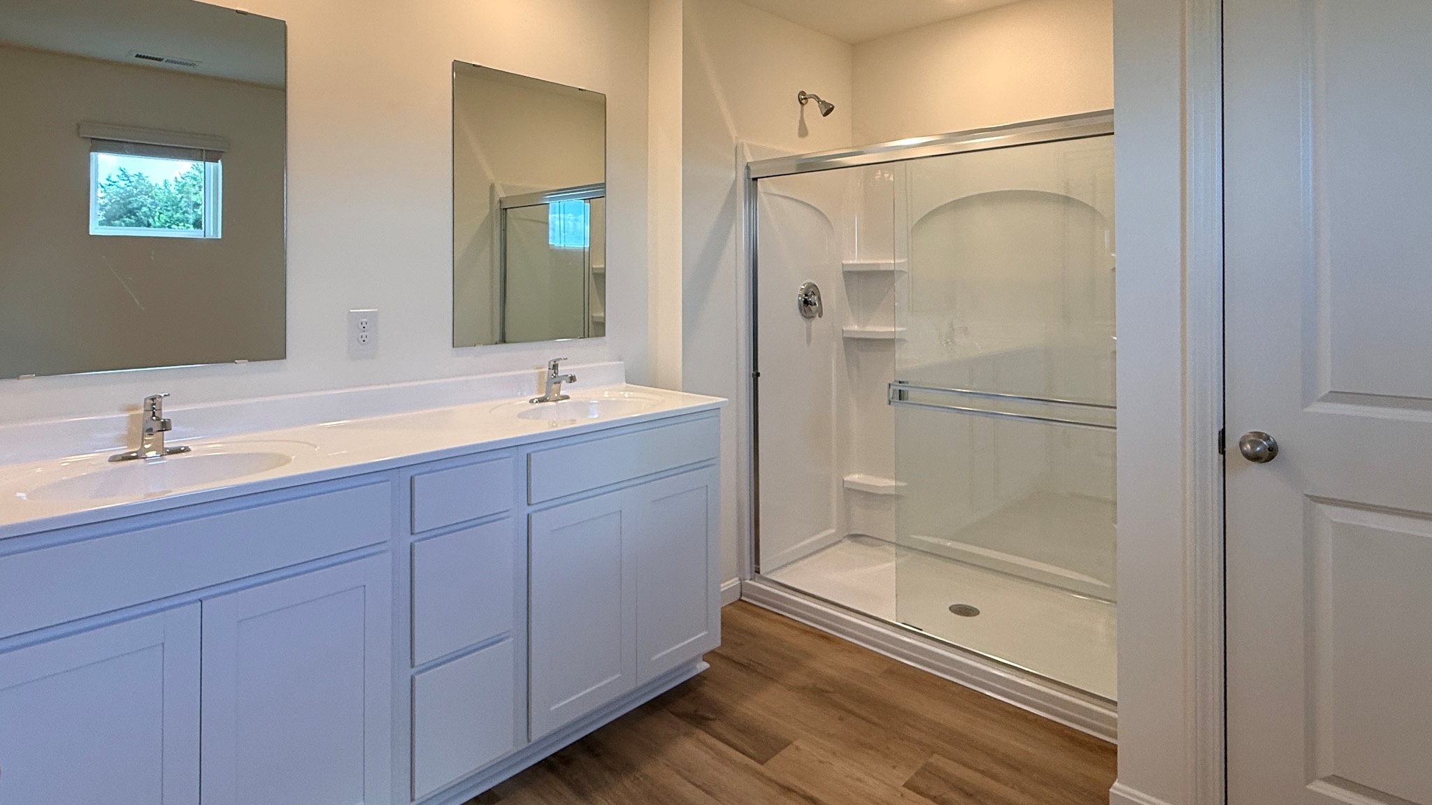 Second floor primary bathroom with double bowl vanity, walk-in shower, and water closet door.