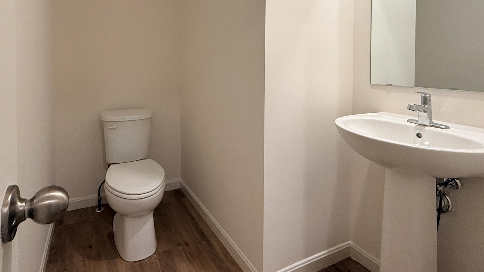 First floor half bathroom with commode and pedestal sink.