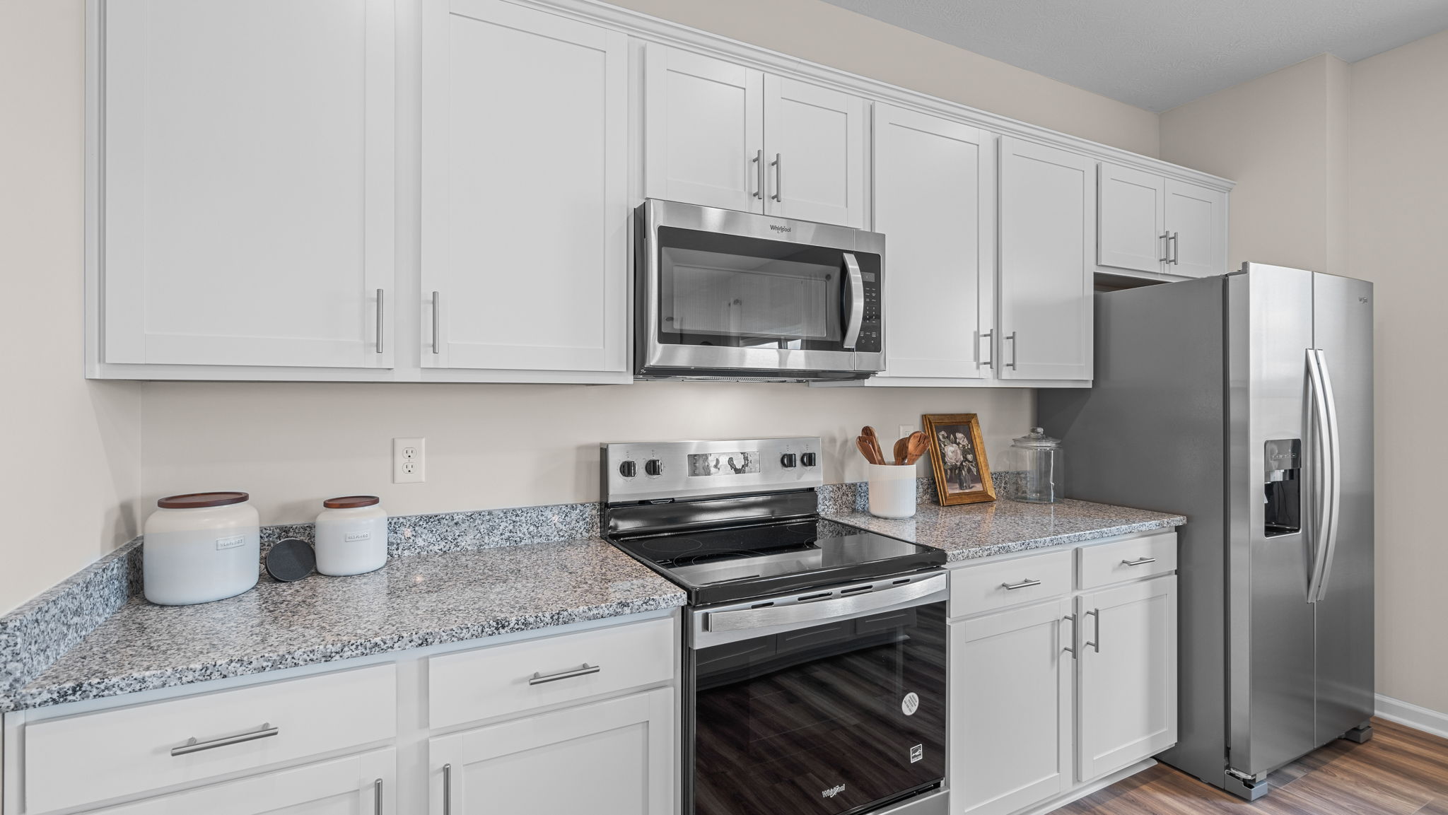 Close up view of kitchen cabinets. White cabinets and stainless steel appliances.