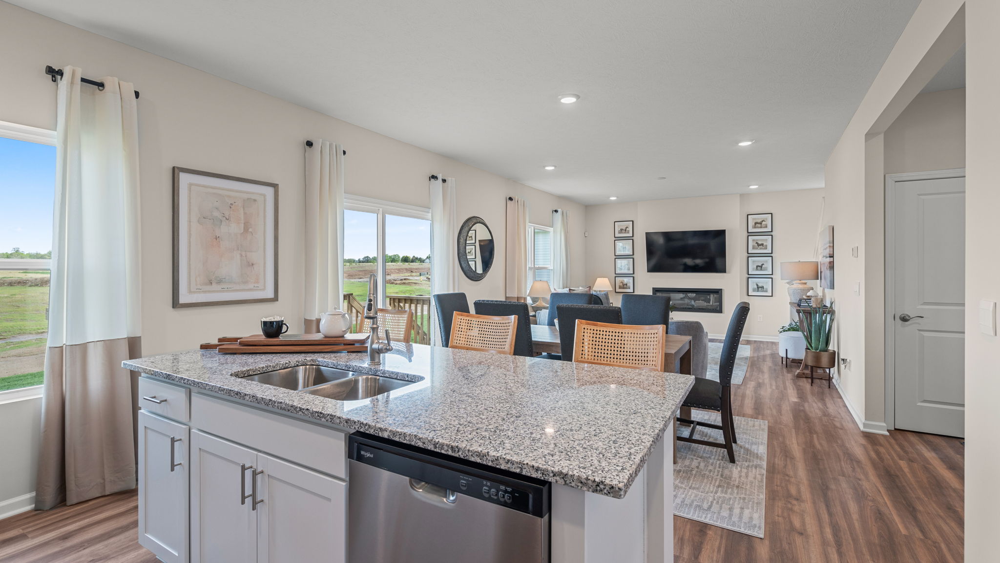 View of dining area and living room standing in kitchen overlooking the kitchen island.
