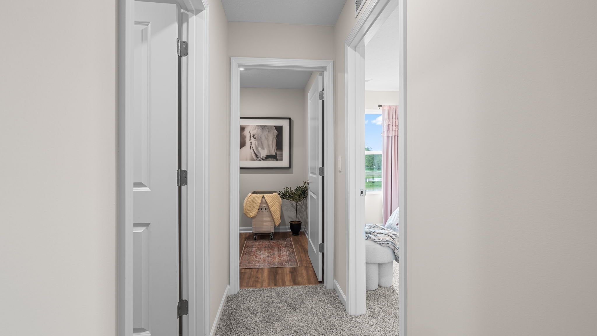 Upstairs hallway facing the laundry room door and a bedroom door.