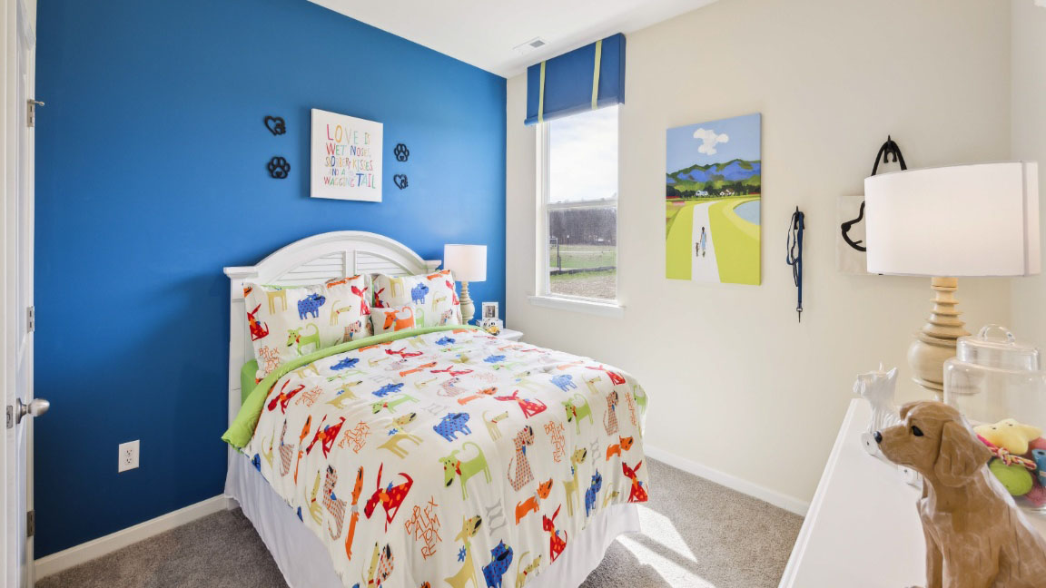bedroom featuring a dark blue accent wall, animal decor, and a small window to the right of the bed