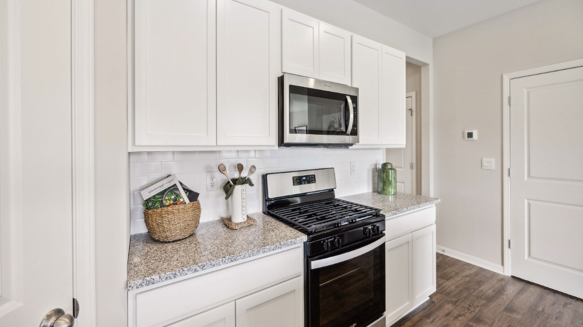 beautiful modern kitchen with white cabinetry, stainless steel appliances, grey countertops