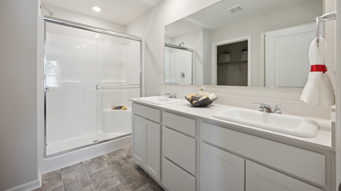 Primary bathroom with double bowl vanity and walk-in shower