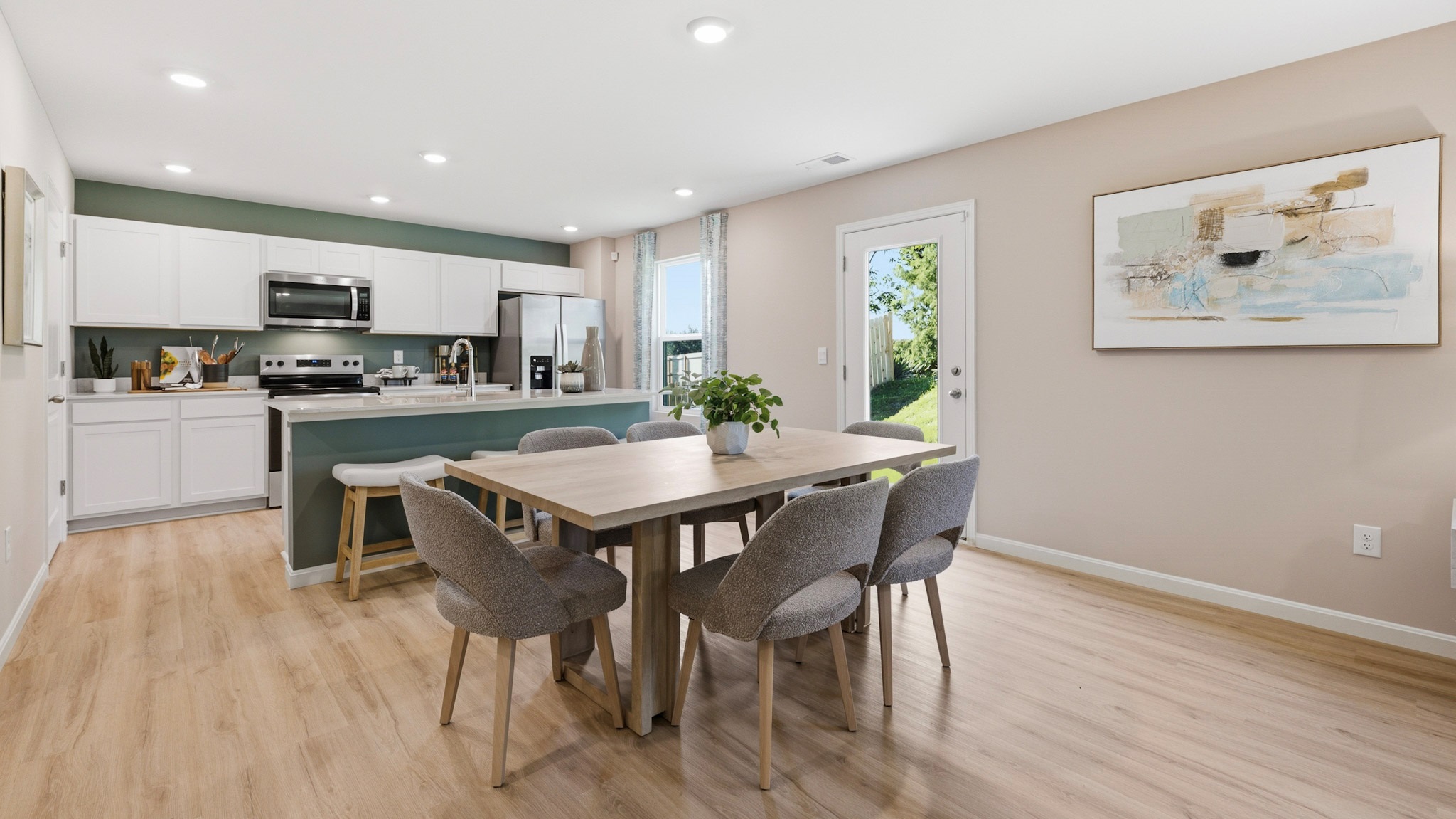Spacious kitchen with white cabinets, quartz countertops, and stainless-steel appliances.