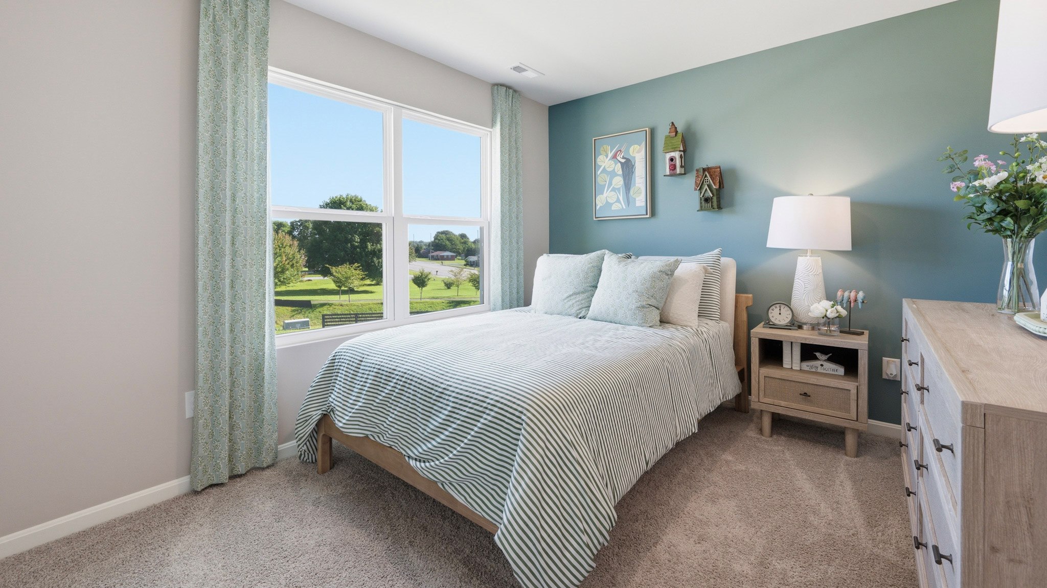 Spare bedroom with double window, bed, dresser, and nightstand with lamp.