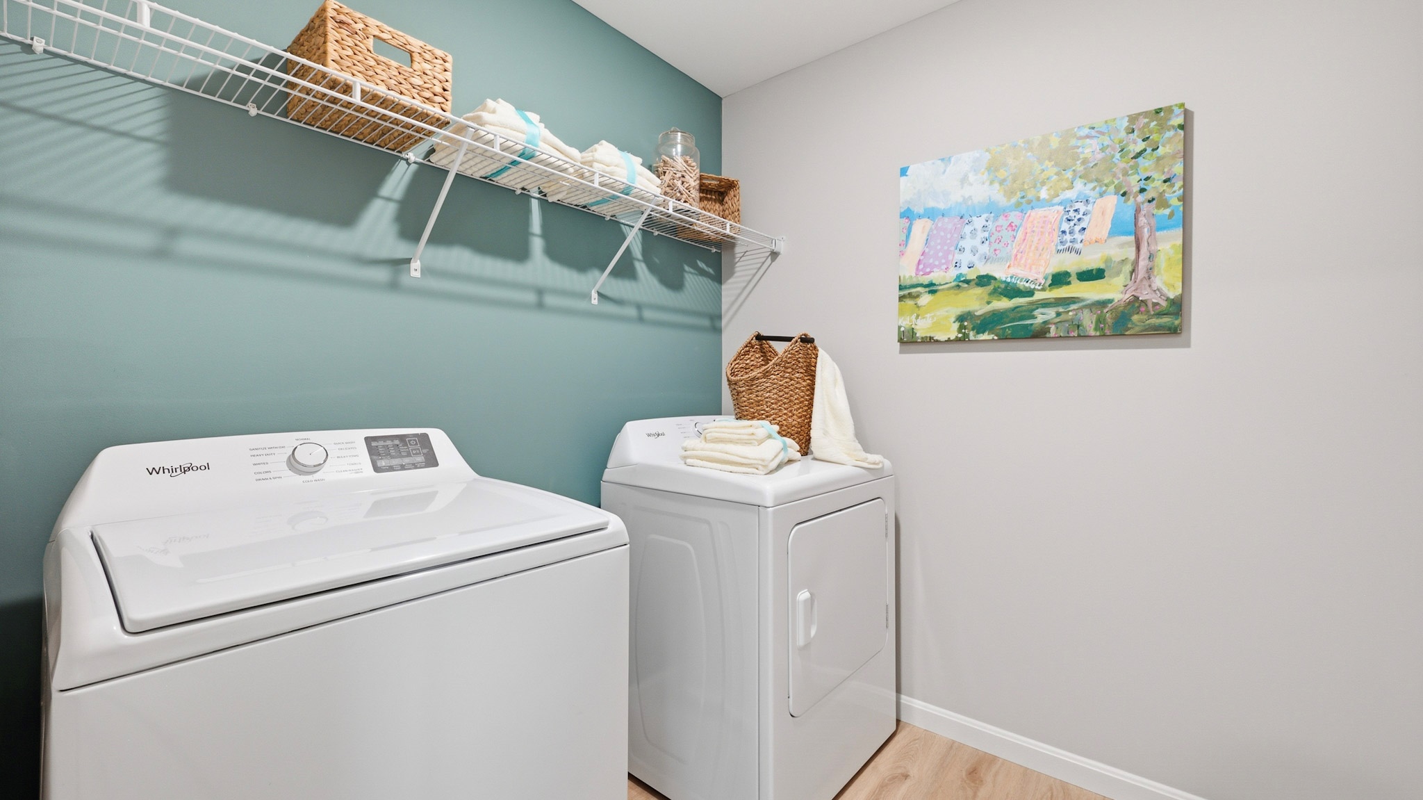 Second floor laundry room with a wire shelf above the washer and dryer.