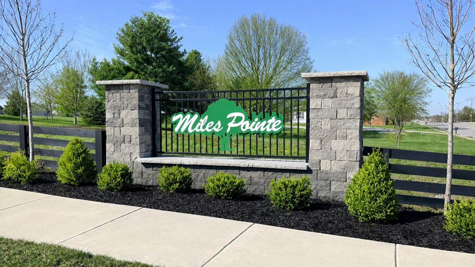 Miles Pointe entrance sign with stone columns on each side.