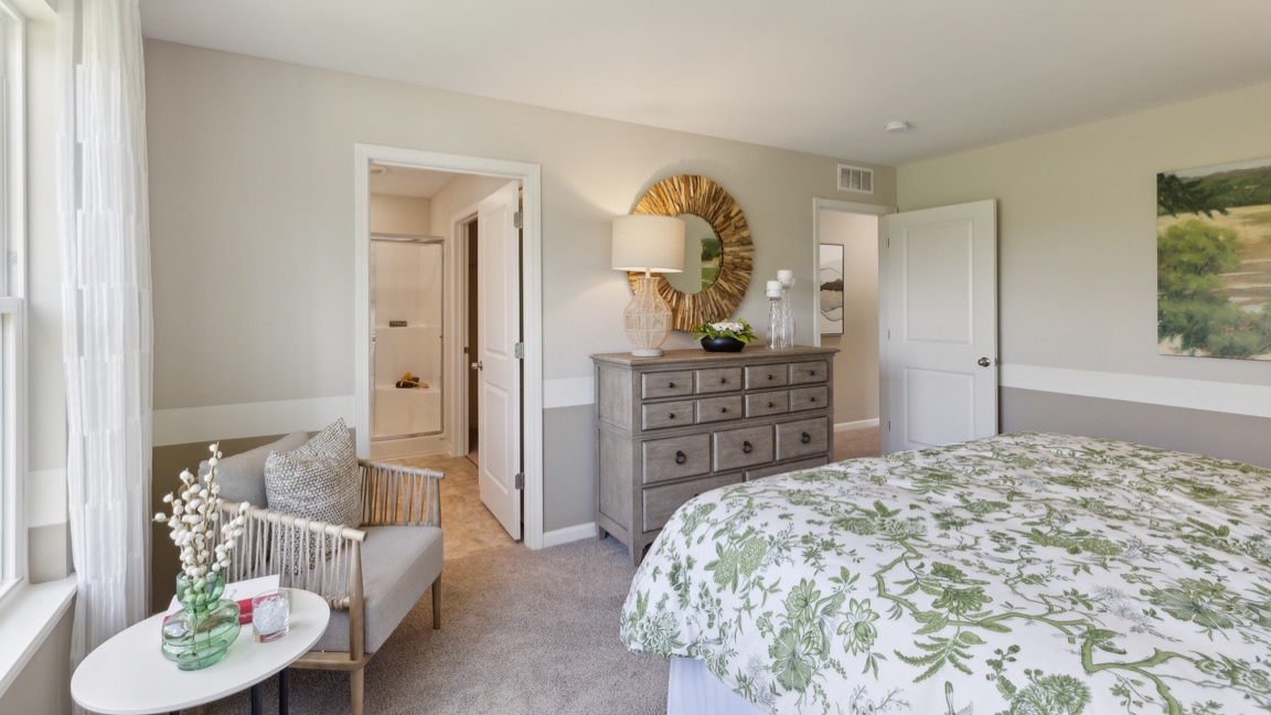Other view of living room with bed, tv dresser, accent chair, bedroom entry door, and bathroom entry door.