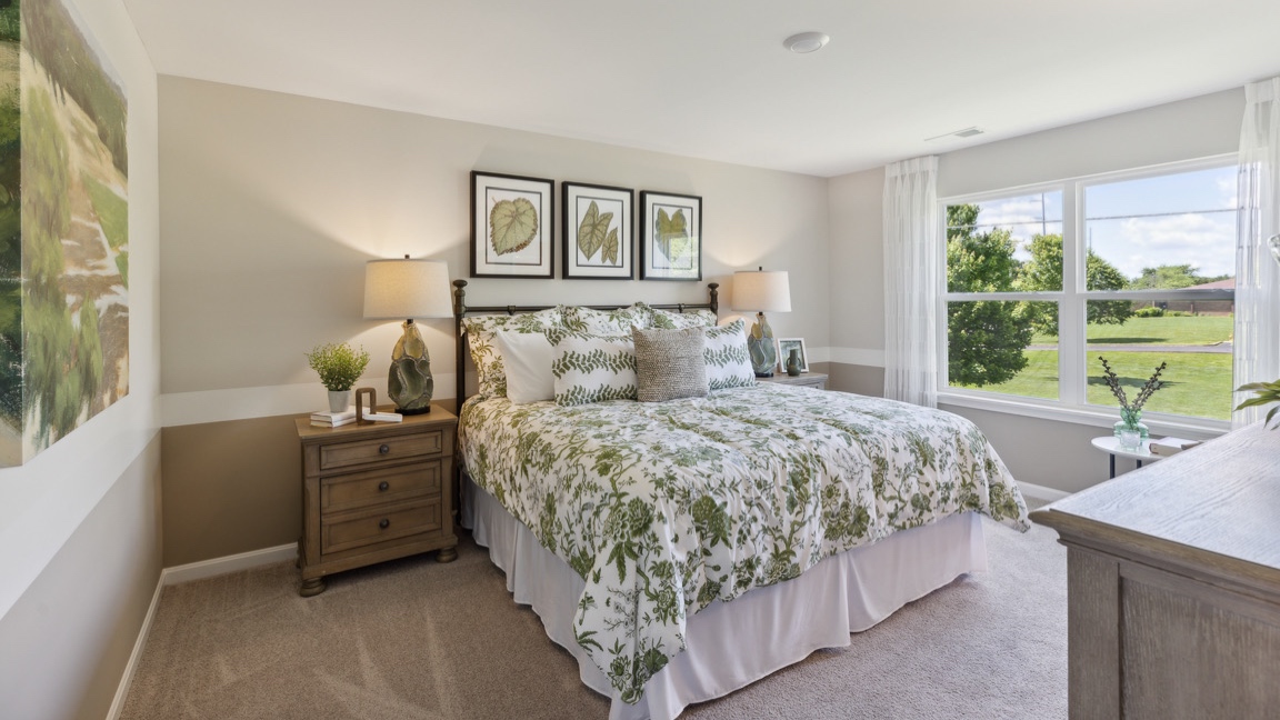 Upstairs primary bedroom with king size bed, 2 nightstands, tv stand, and double window facing back yard.