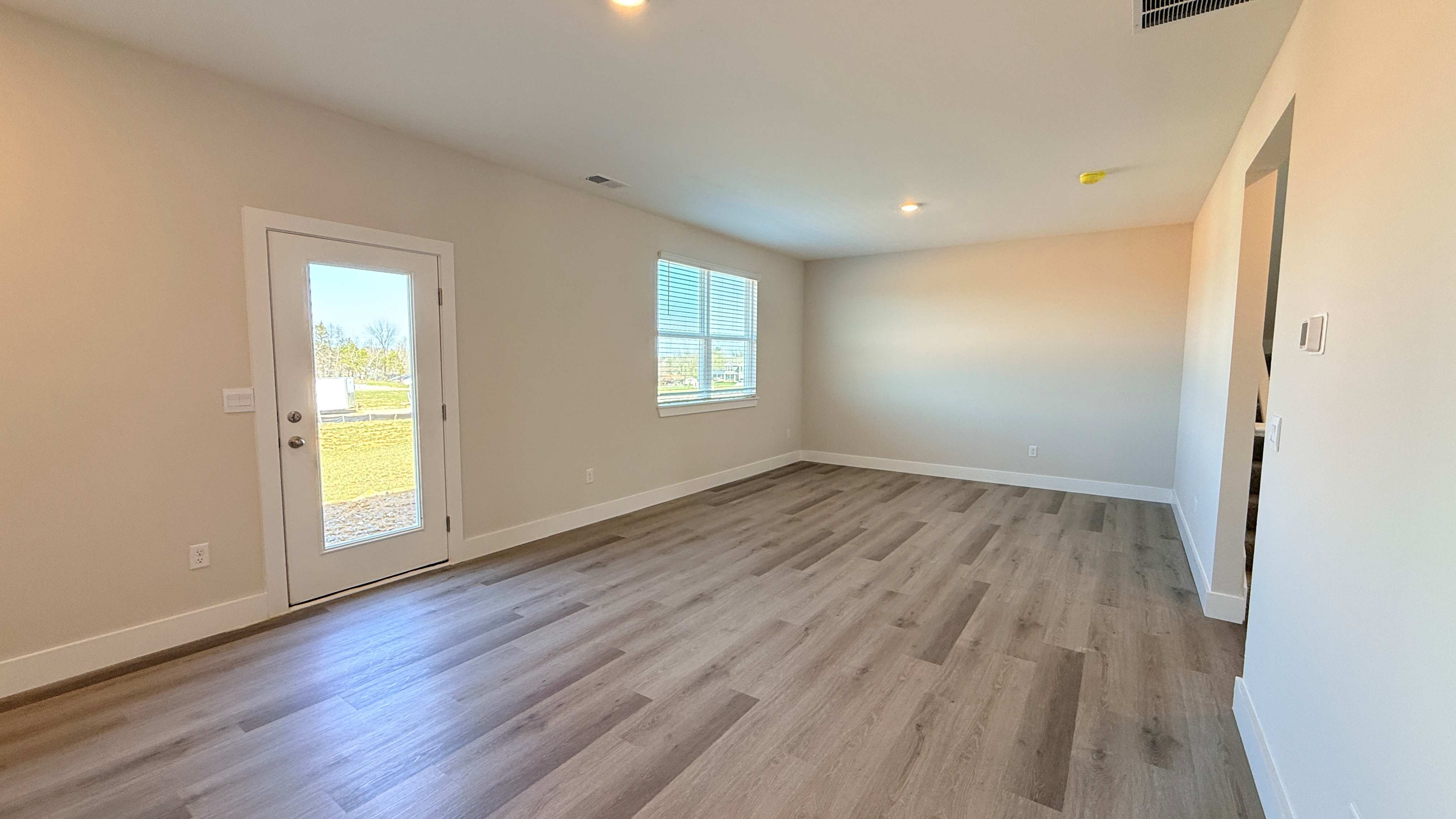 Dining area and living room with luxury vinyl plank flooring.