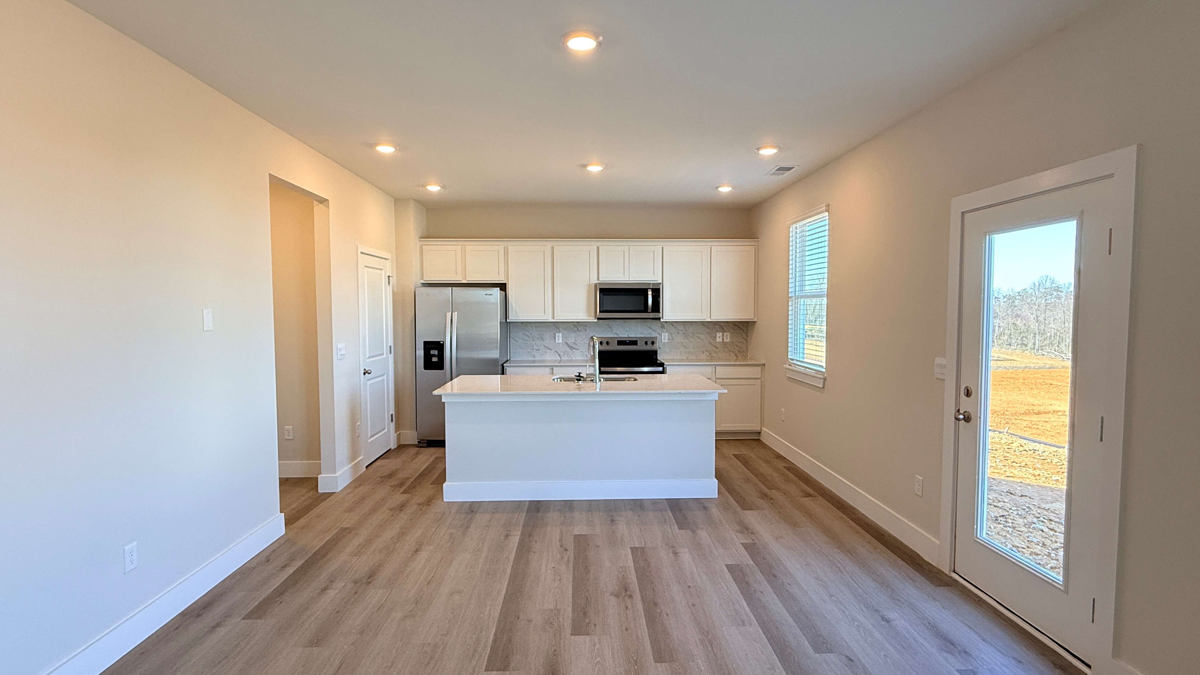 Kitchen with white cabinets, island, and stainless steel appliances.