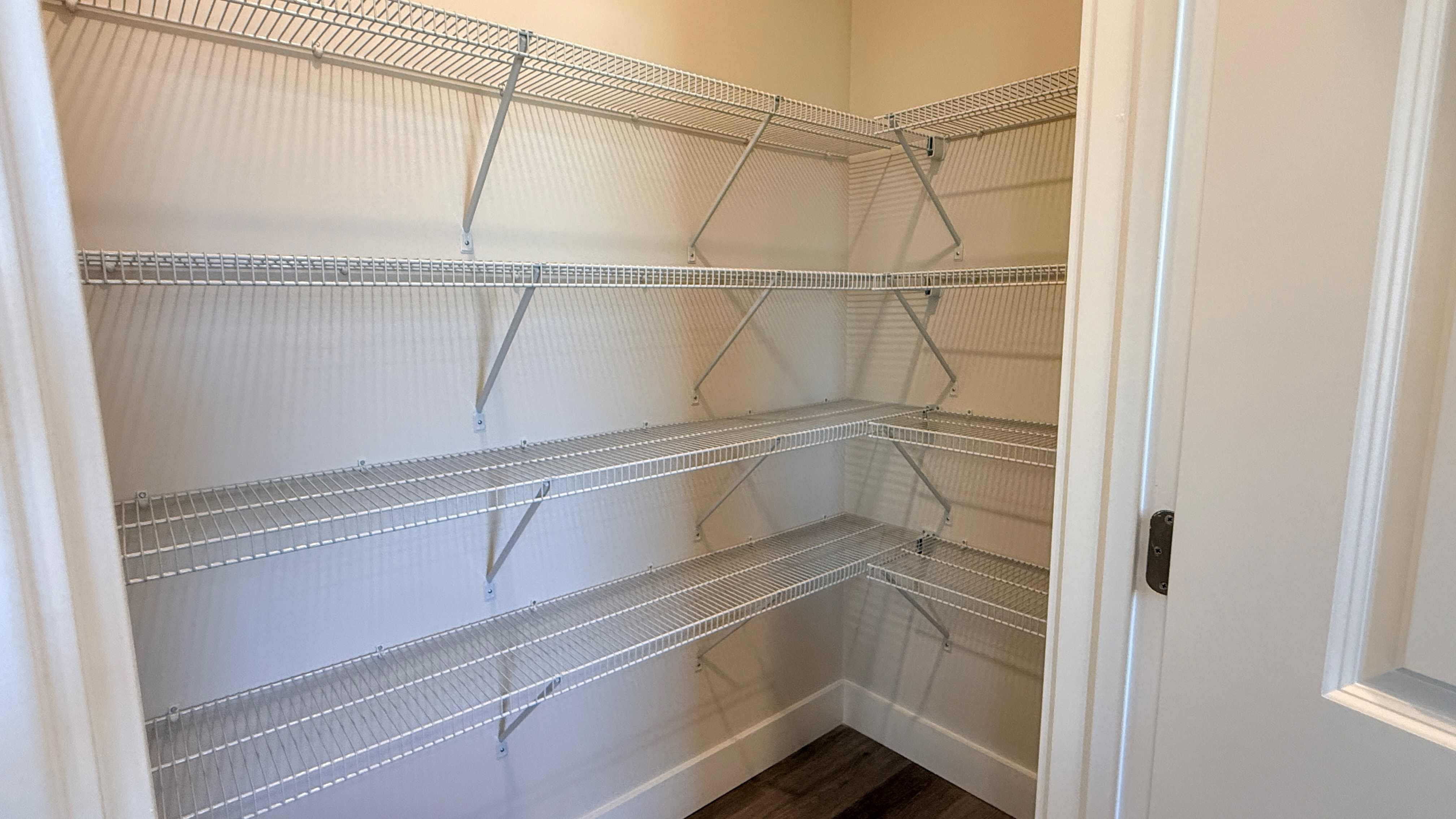 Walk-in pantry with 4 rows of wire shelving.
