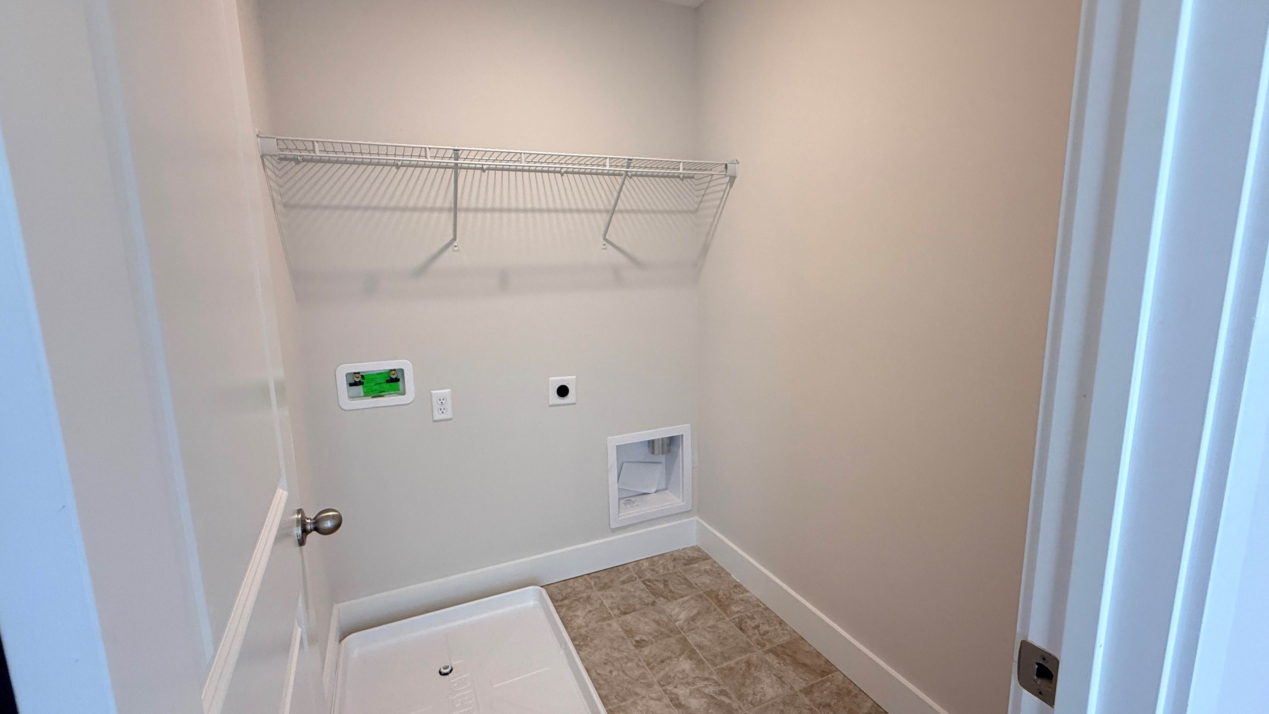 Laundry room with wire shelf and washer pan.