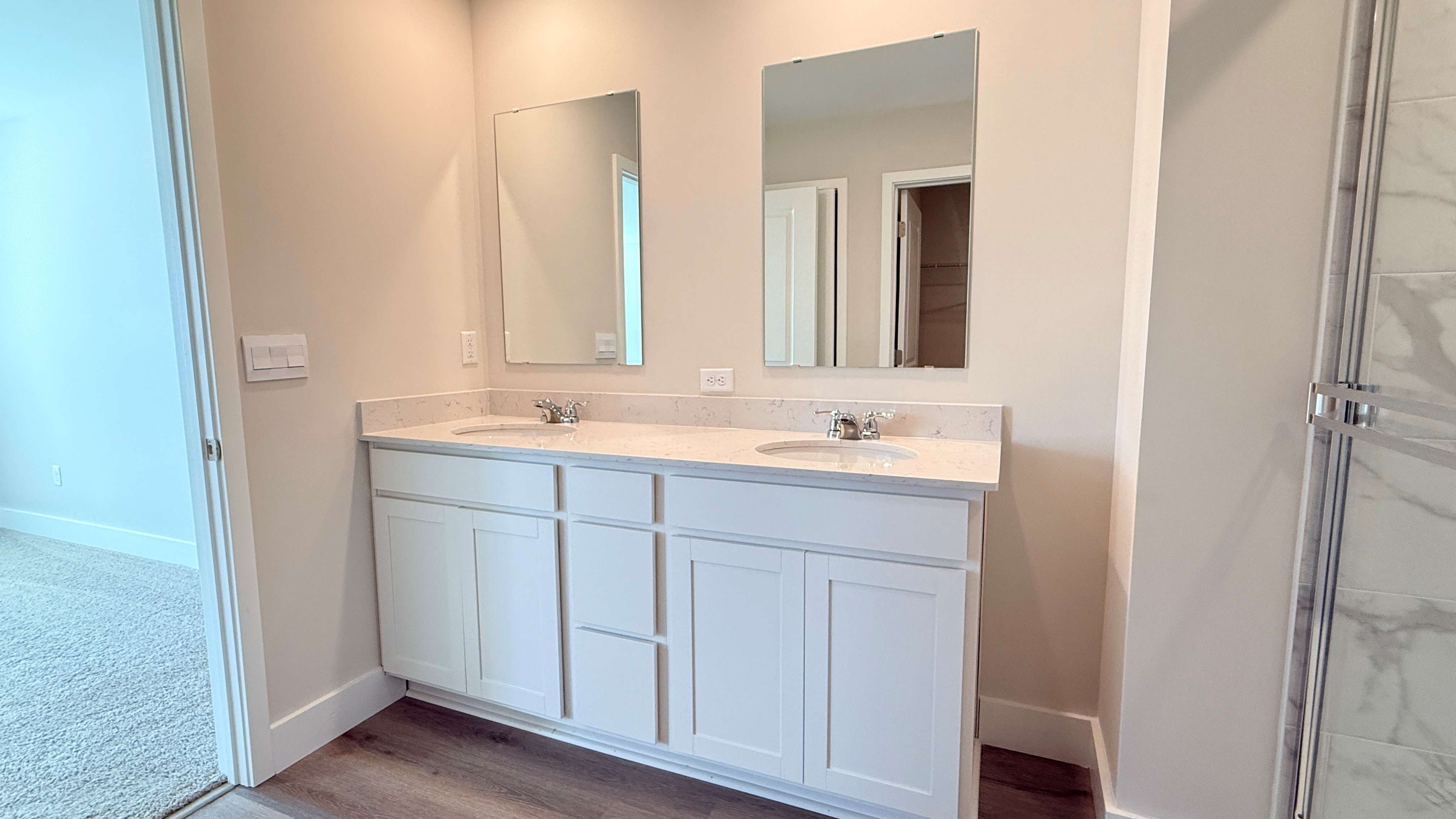 Primary bathroom with double bowl vanity with mirror above both sinks.