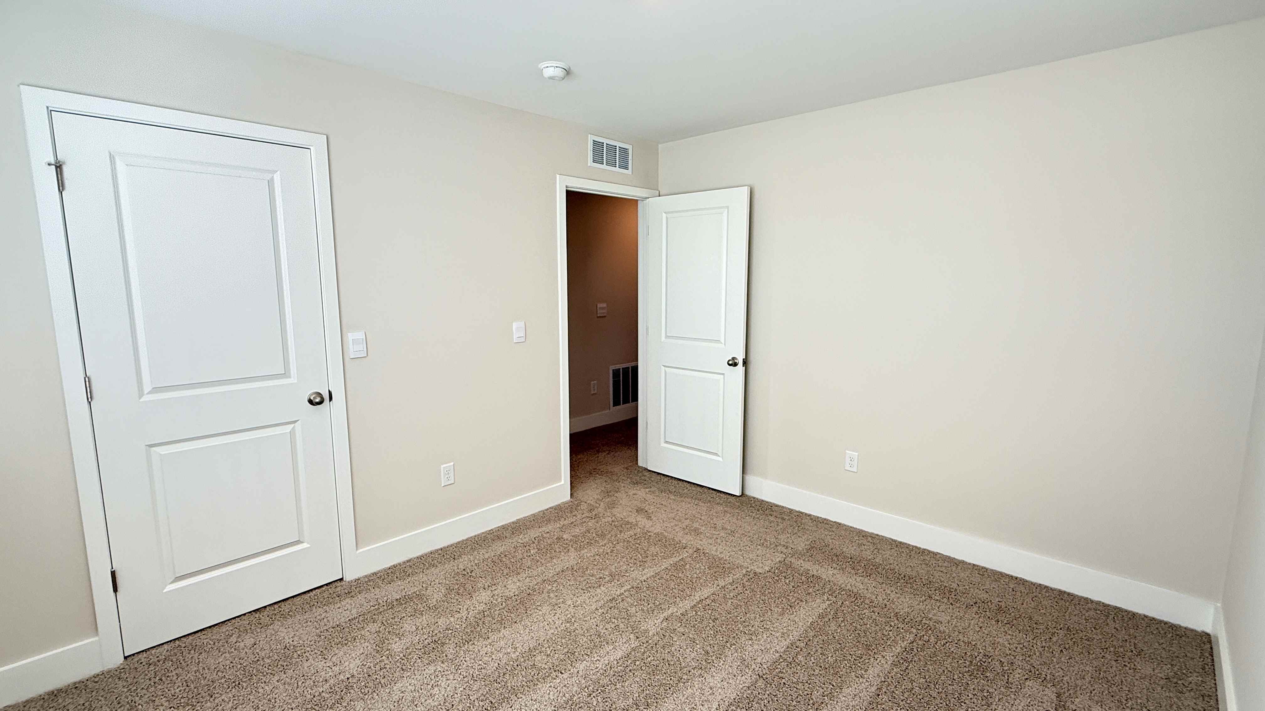 Other view of spare bedroom with closet and bedroom door.