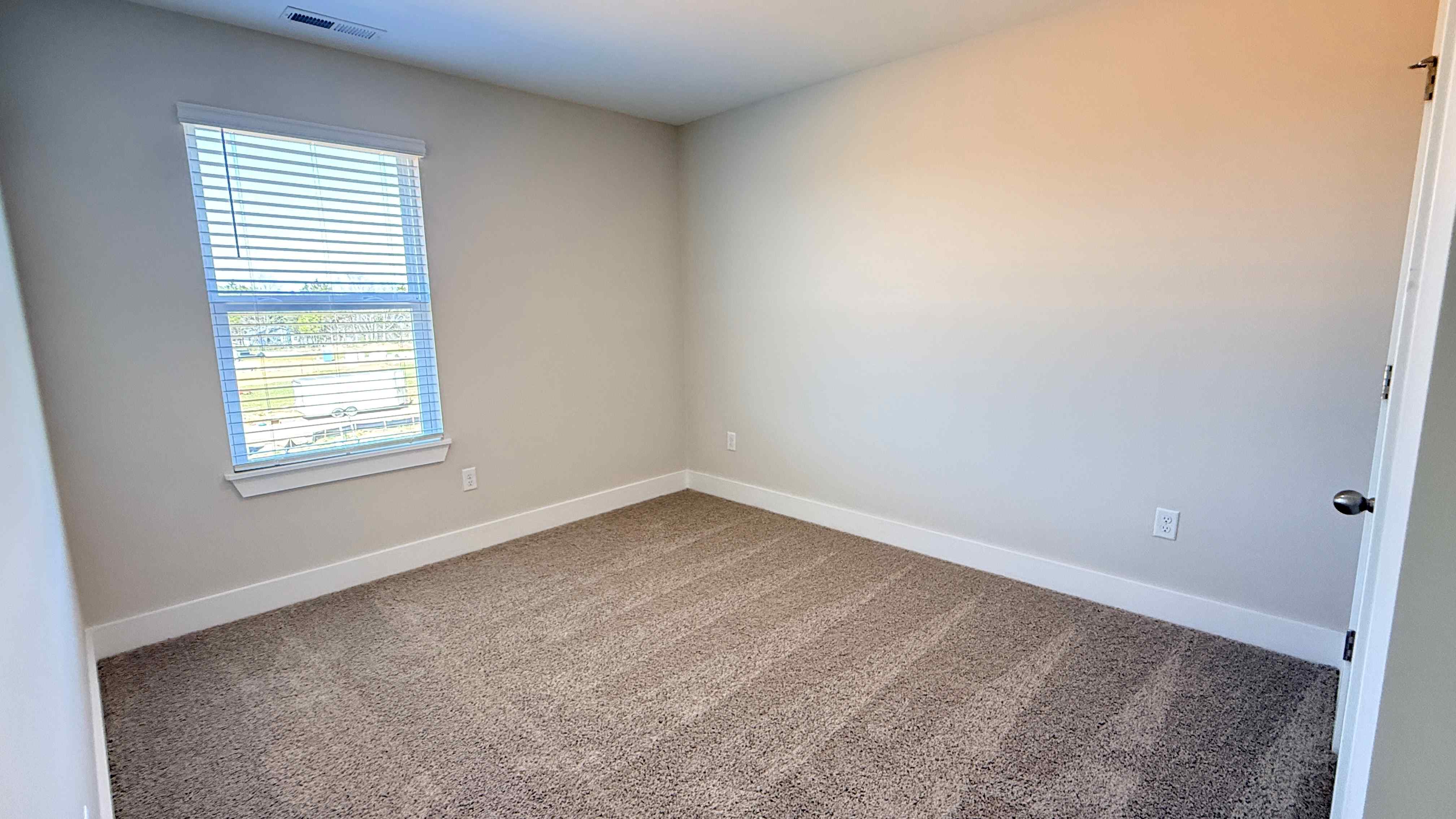 Upstairs spare bedroom with single window.