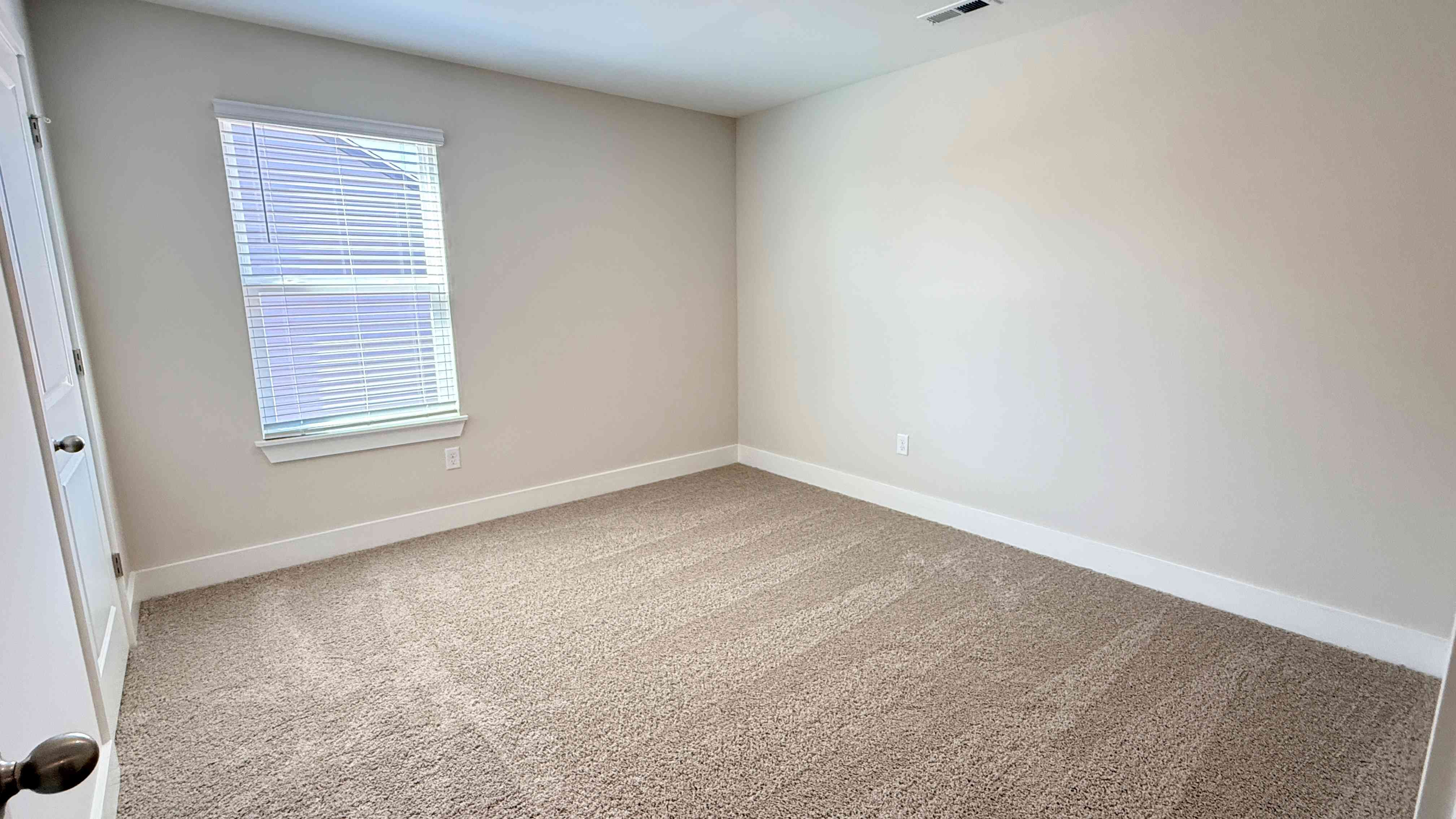 Upstairs spare bedroom with single window.