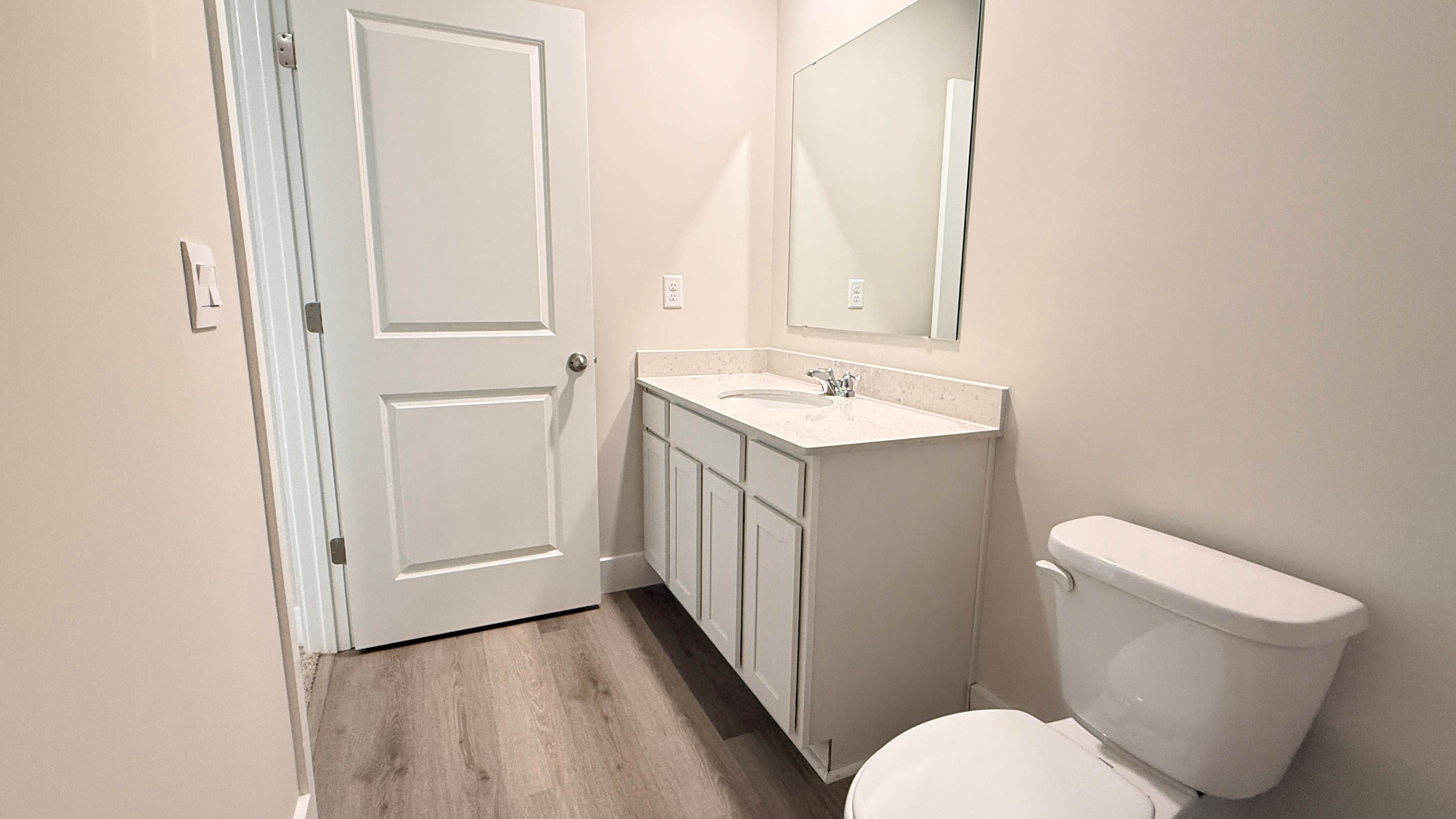 Upstairs shared bathroom with large vanity, commode, and shower/tub combo.