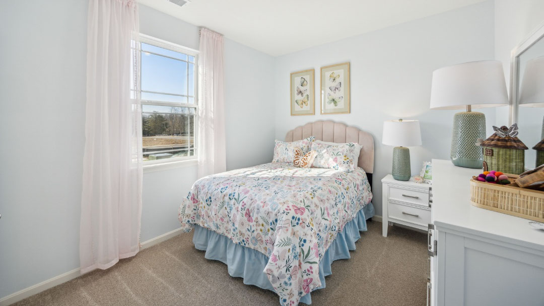 bedroom featuring pastel decor, a twin bed, white dresser and nightstand and a window