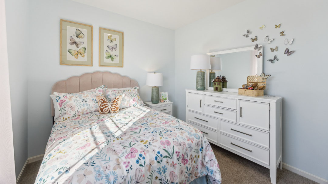 bedroom featuring pastel decor, a twin bed, white dresser and nightstand and a window