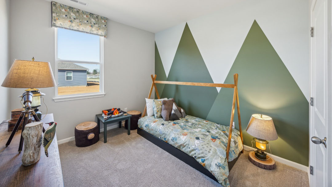 bedroom featuring green triangle accent wall, small bed, and woodsy decor