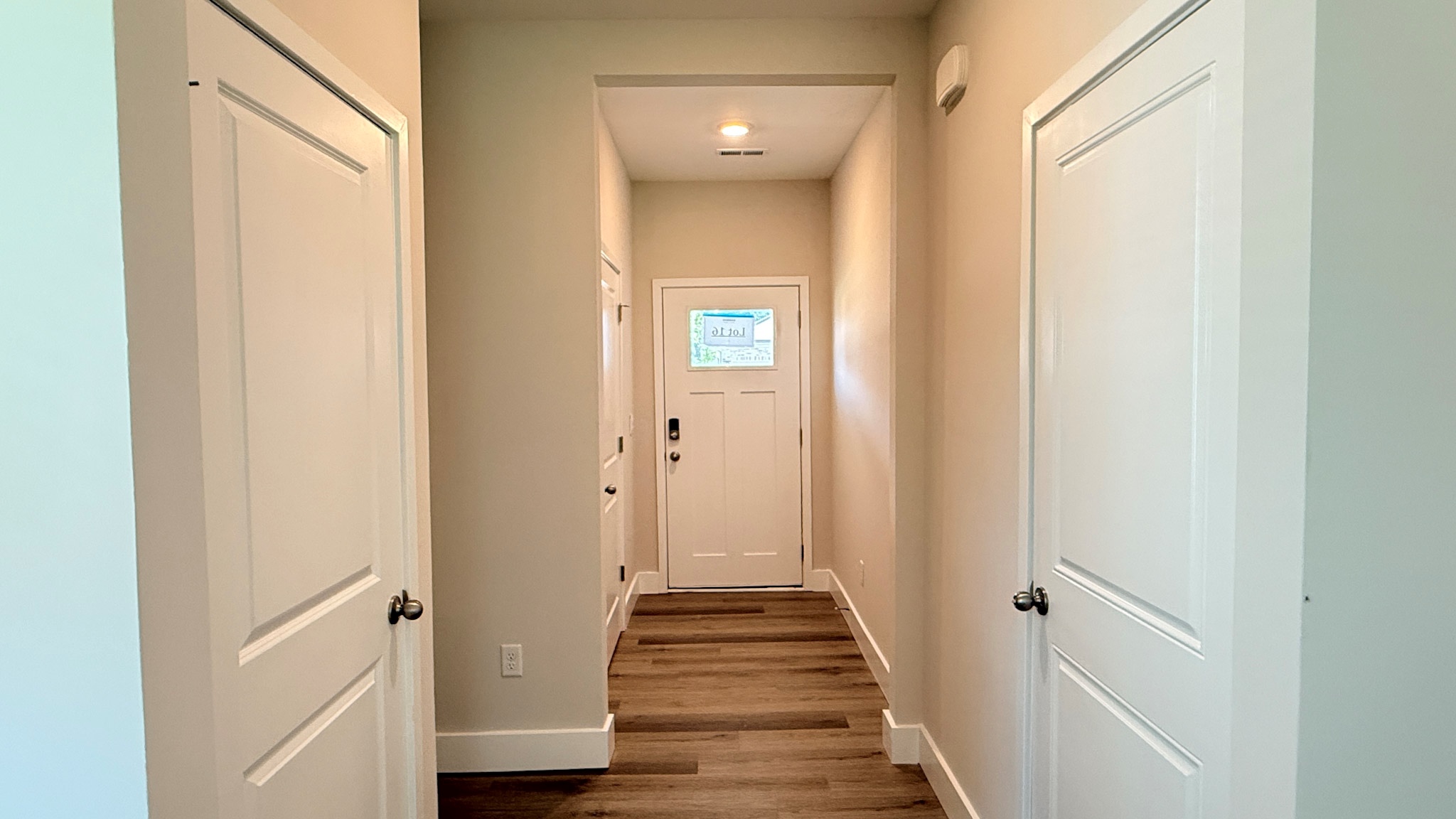 Foyer facing the front door with luxury vinyl plank flooring.
