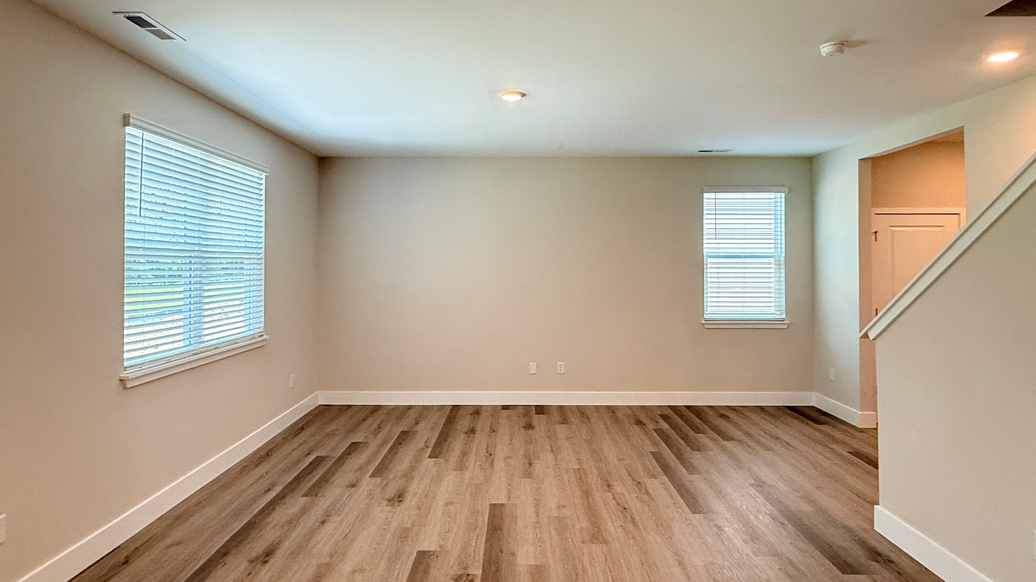 Living room with a double window overlooking the rear yard and then a single window overlooking the side yard.