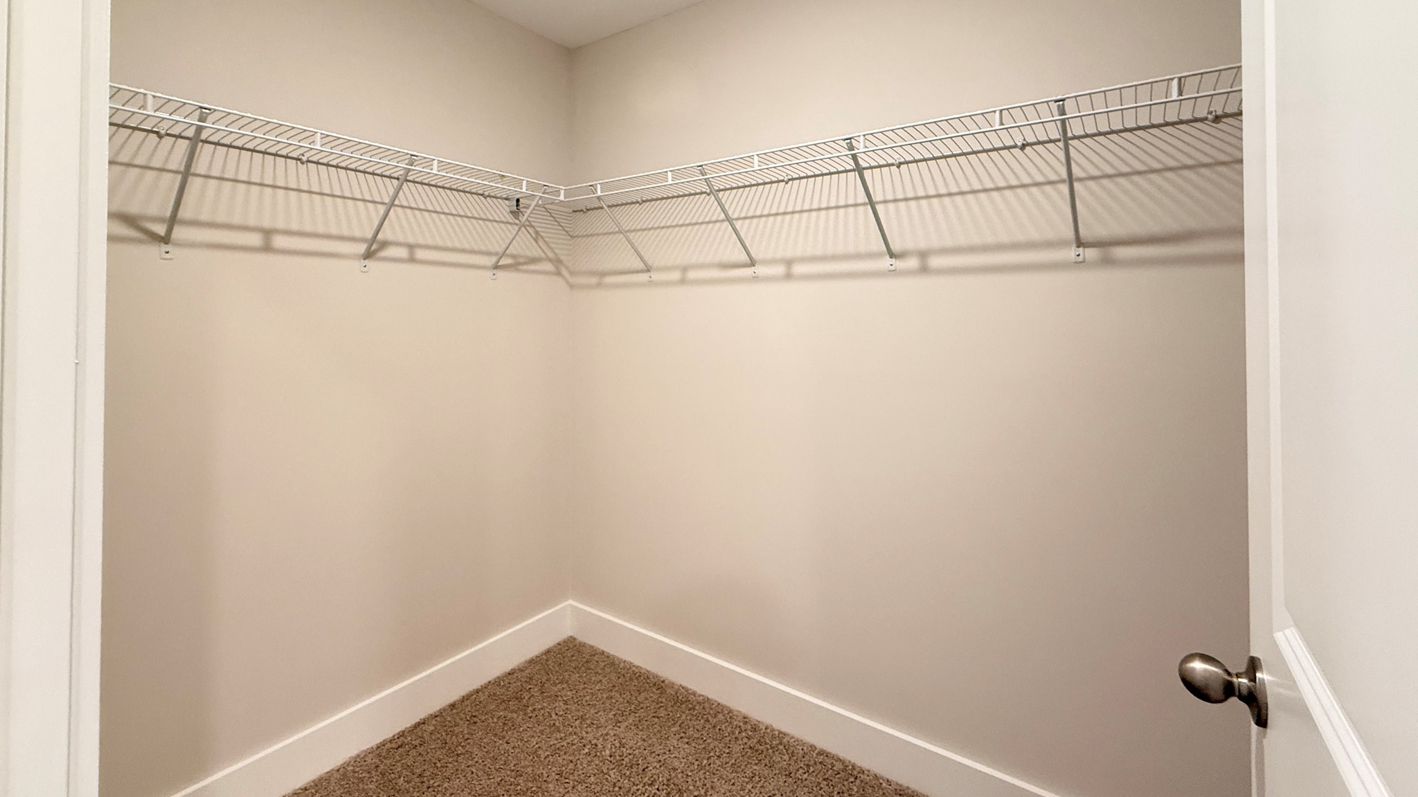 Primary walk-in closet with wire shelving.